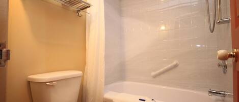A bathroom with a toilet, a shower, and a bathtub.