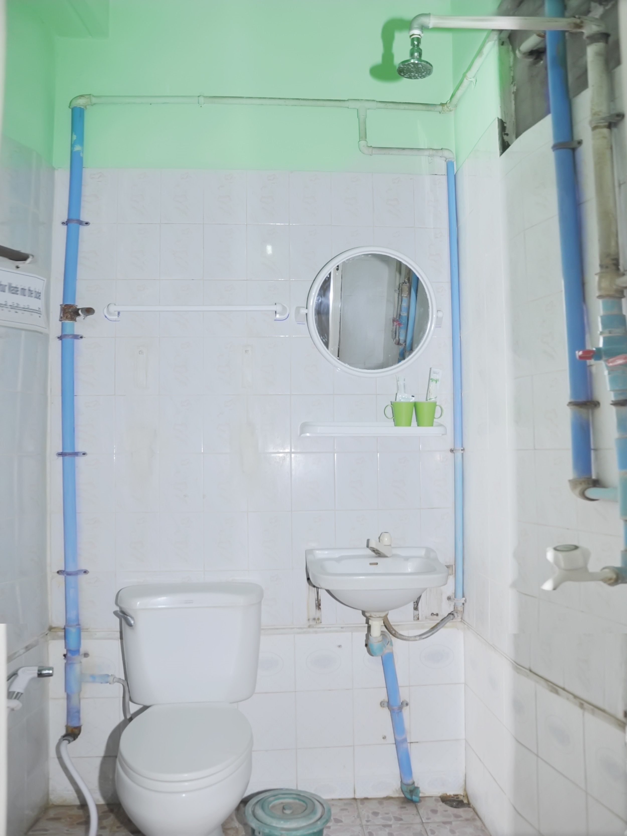 A bathroom with a toilet, sink, and mirror.