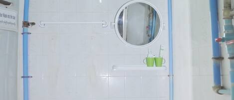 A bathroom with a toilet, sink, and mirror.