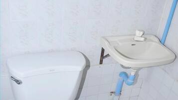 Un baño con inodoro, lavabo y espejo.