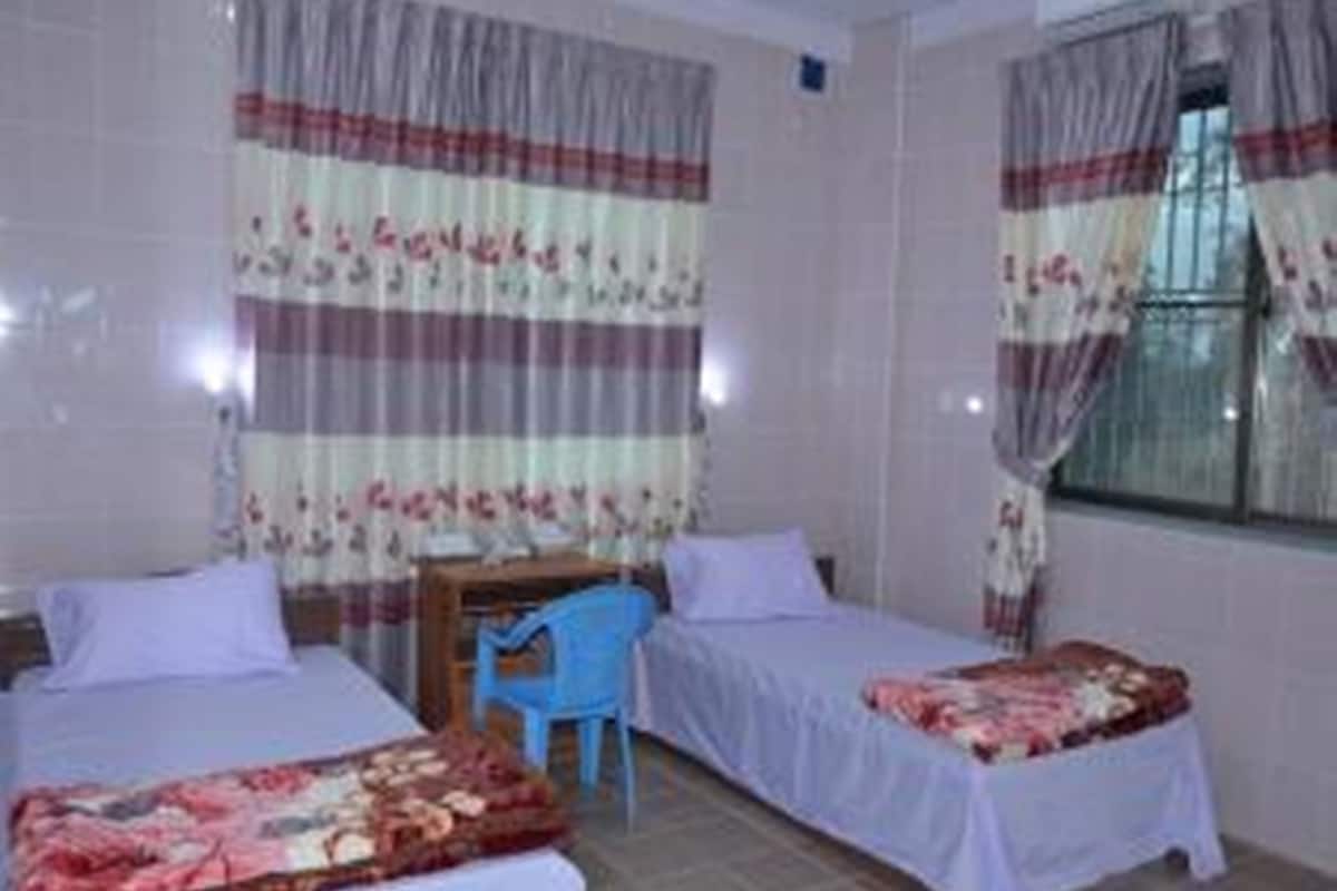 A room with two beds, a desk, and a chair.