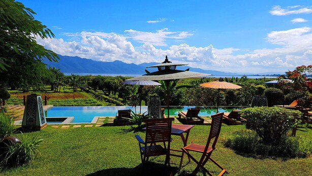 A pool area with a view of mountains, a gazebo, and a table with chairs. - Inle Lake View Resort & Spa (Nyaungshwe)