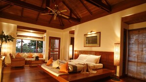 A spacious bedroom with a large bed, wooden ceiling, and a view of the outdoors through a window. - Inle Lake View Resort & Spa (Nyaungshwe)