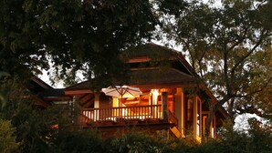 A wooden cabin with a balcony, surrounded by trees. - Inle Lake View Resort & Spa (Nyaungshwe)