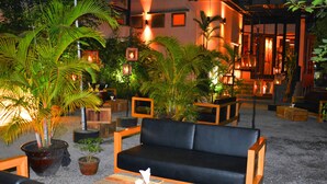 Un espacio de estar al aire libre con muebles de madera y plantas en macetas.