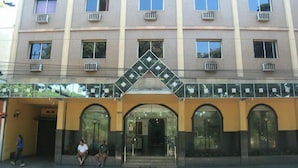 Un edificio de varios pisos con una entrada central que presenta arcos y un diseño decorativo de diamantes en la parte superior.