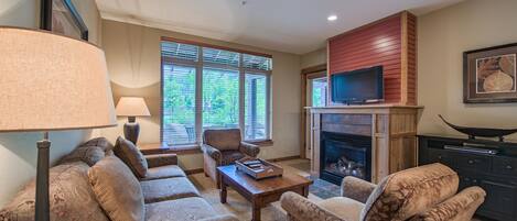 A living room with a fireplace, a television, and a sofa set.