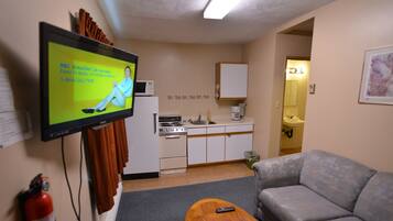 Suite Deluxe, 1 habitación | Área de sala de estar | Televisión de pantalla plana