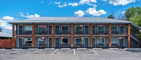Ein zweistöckiges Motel mit Parkplatz davor.