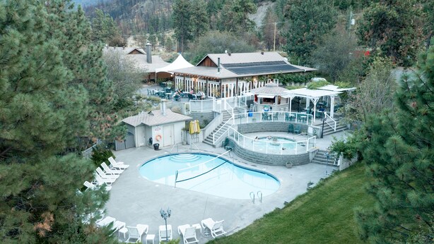 Un resort con piscina, mobiliario exterior y un patio cubierto.