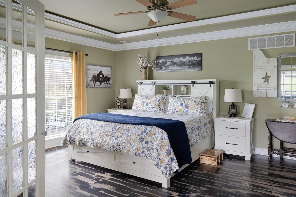 A bedroom with a bed, nightstands, a dresser, and a desk.