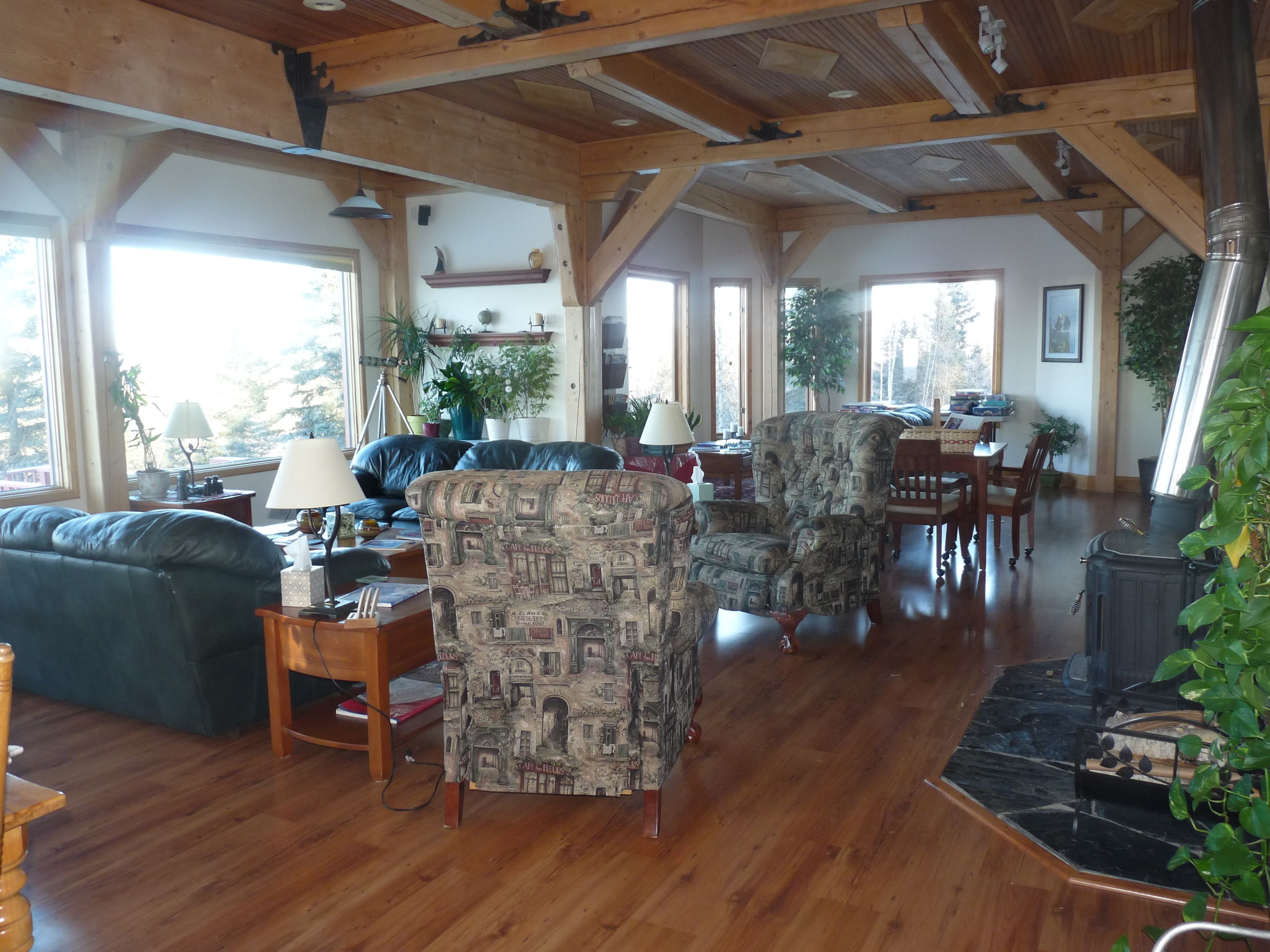 A spacious living room with wooden floors, a fireplace, and a dining area with wooden furniture.