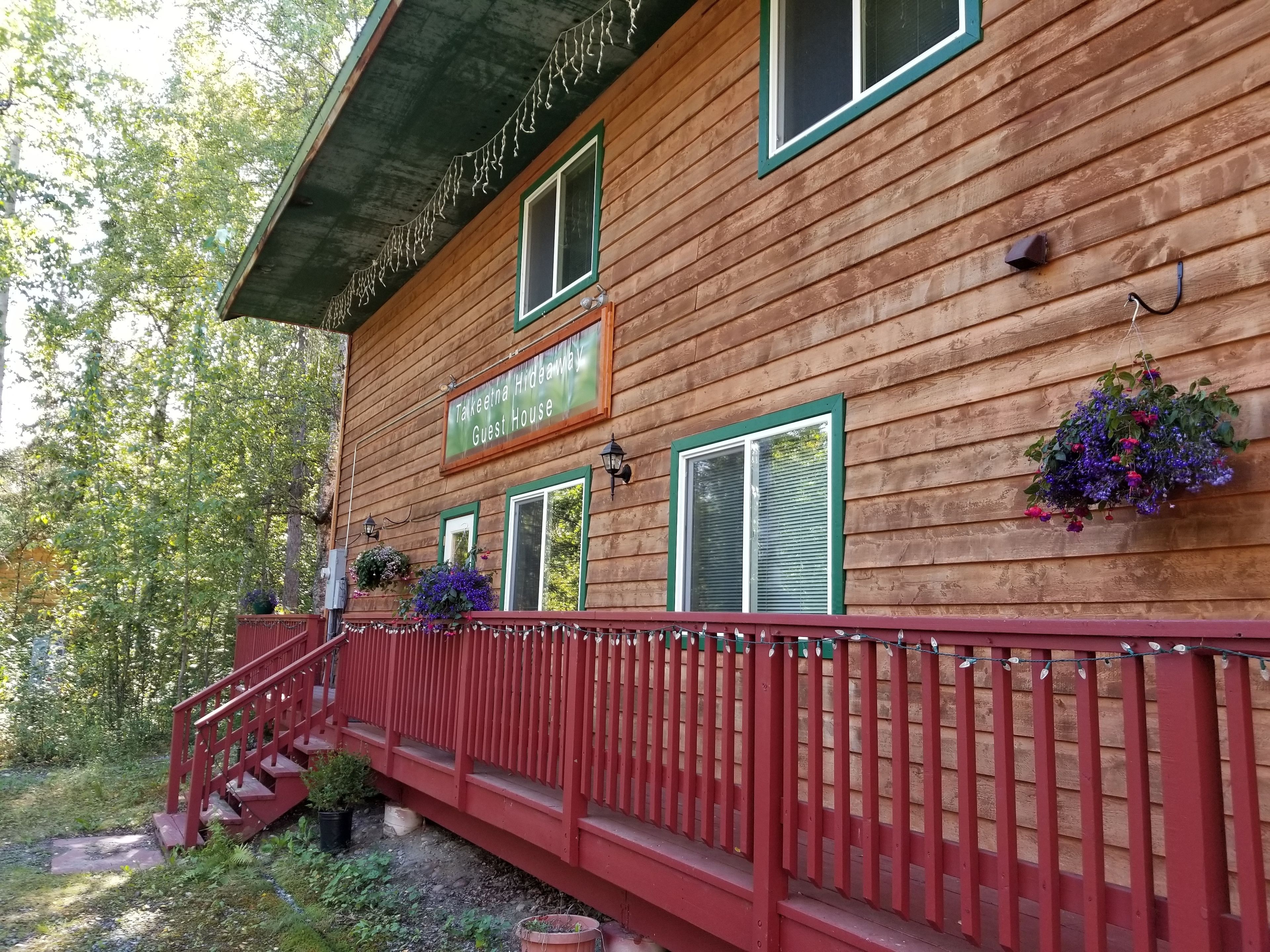 A wooden guest house with a sign reading "Takkeetha Hideaway Guest House."