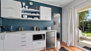 Una cocina moderna con armarios blancos, un microondas y un refrigerador.