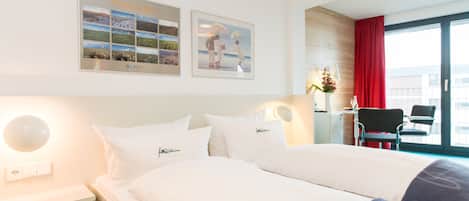 Habitación de hotel con una cama grande, un escritorio con silla y vistas a la ciudad desde la ventana.