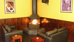 A cozy room with a fireplace, leather sofas, and framed pictures on the walls.