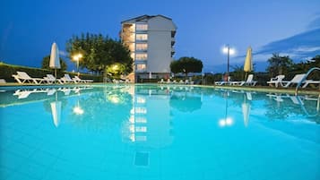 Una piscina al aire libre de temporada, sillones reclinables de piscina