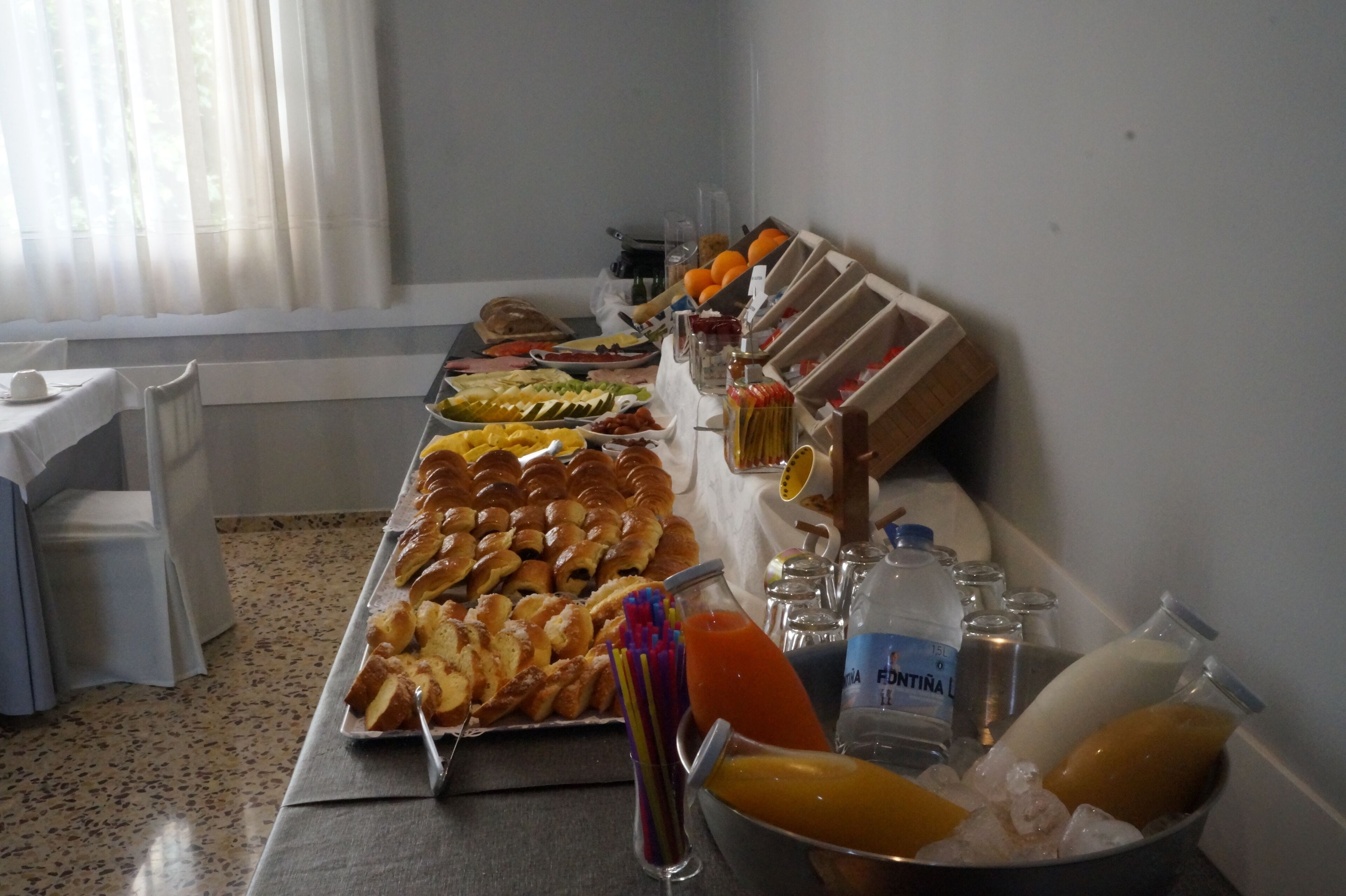Uma mesa de buffet com diversos alimentos e bebidas.