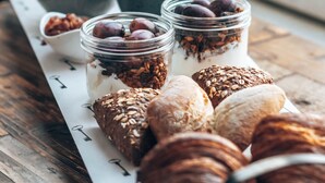 A breakfast table with croissants, yogurt parfaits, and various fruits and nuts. - Eye Hotel (Utrecht)