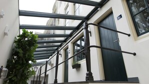 A narrow corridor with a glass ceiling, a tree, and a door labeled "OFF". - Eye Hotel (Utrecht)