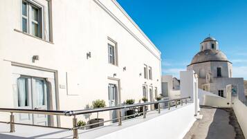 A white building with a dome and a balcony with a metal railing.