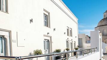A white building with a dome and a balcony with a metal railing.