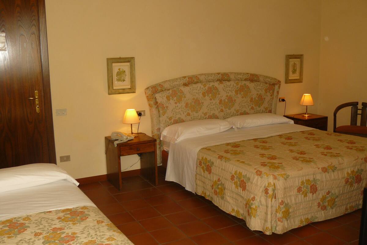 A bedroom with a bed, bedside tables, lamps, and a door.