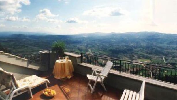 A terrace with a table and chairs, overlooking a mountainous landscape. - Hotel La Rocca (Gubbio)
