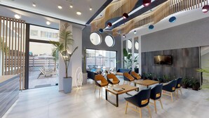 Um espaço interno moderno com área de estar, janelas amplas e uma TV fixada na parede.