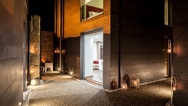 Un edificio moderno con fachada de piedra y detalles de madera.