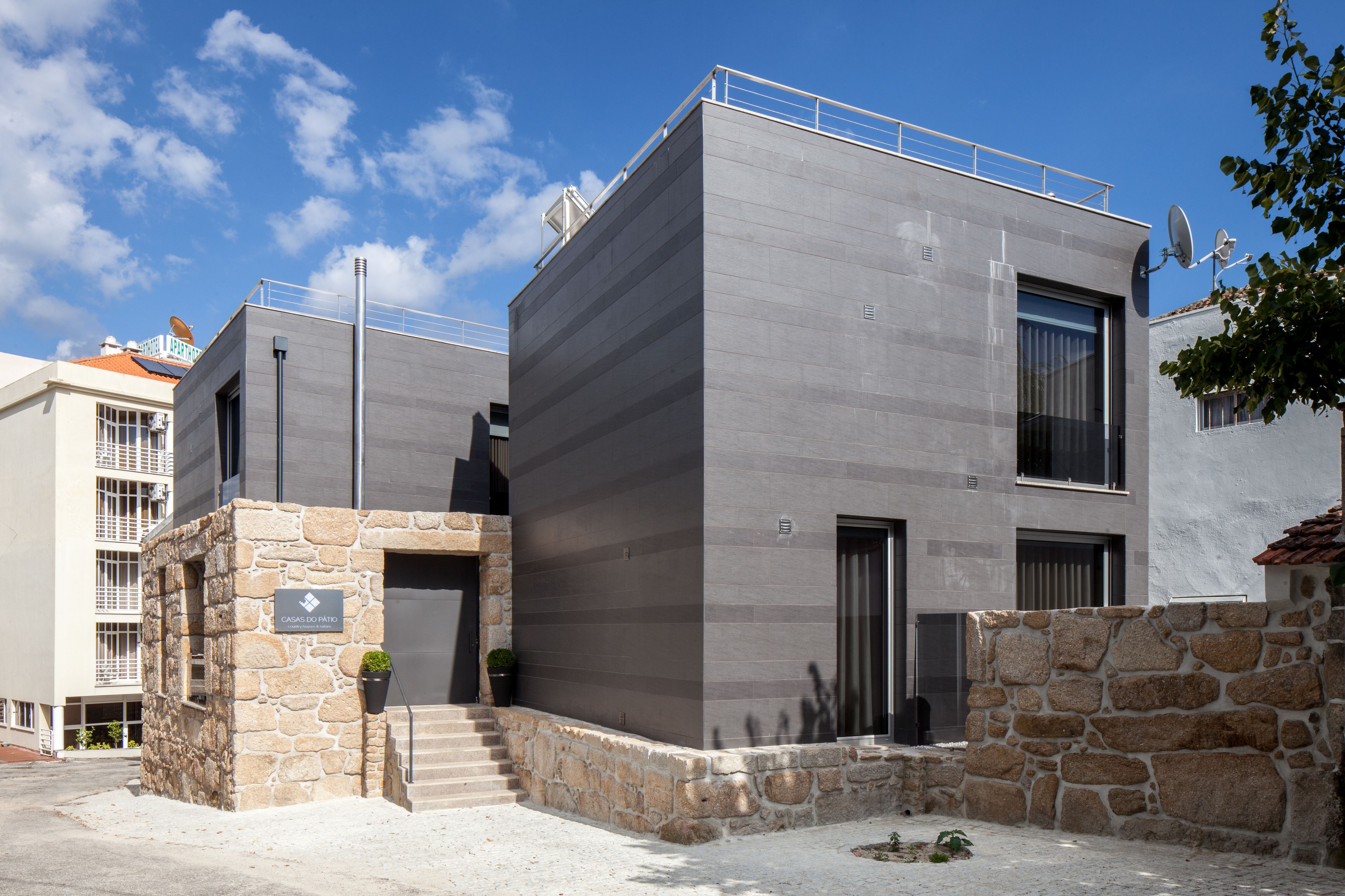 Un edificio moderno con facciata in pietra, ampie finestre e tetto piano.