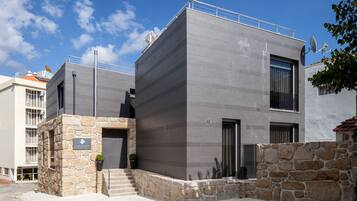 Un edificio moderno con facciata in pietra, ampie finestre e tetto piano.