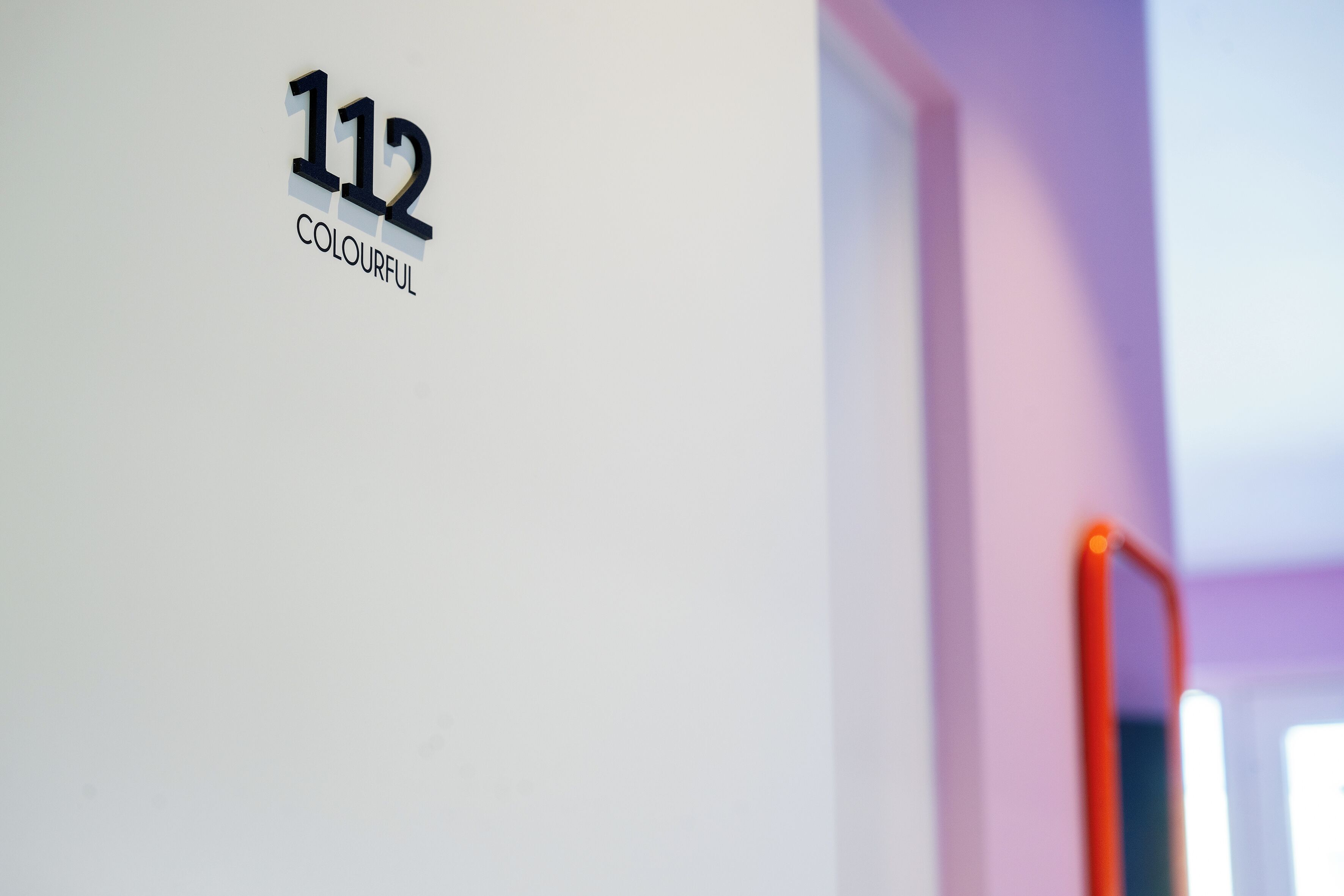 A wall with a sign that reads '112 COLOURFUL.'