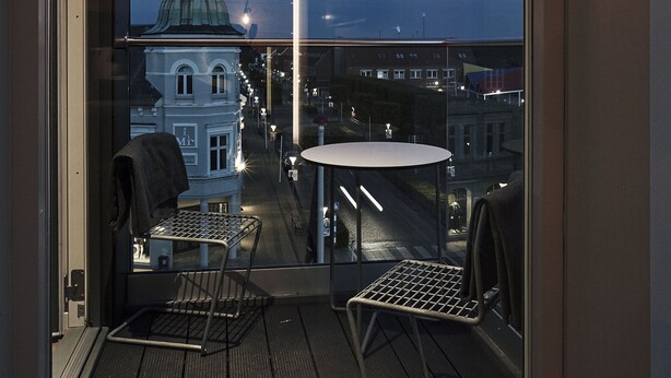 A balcony with a view of a cityscape, including a prominent building with a dome. - Hotel Skjern (Skjern)