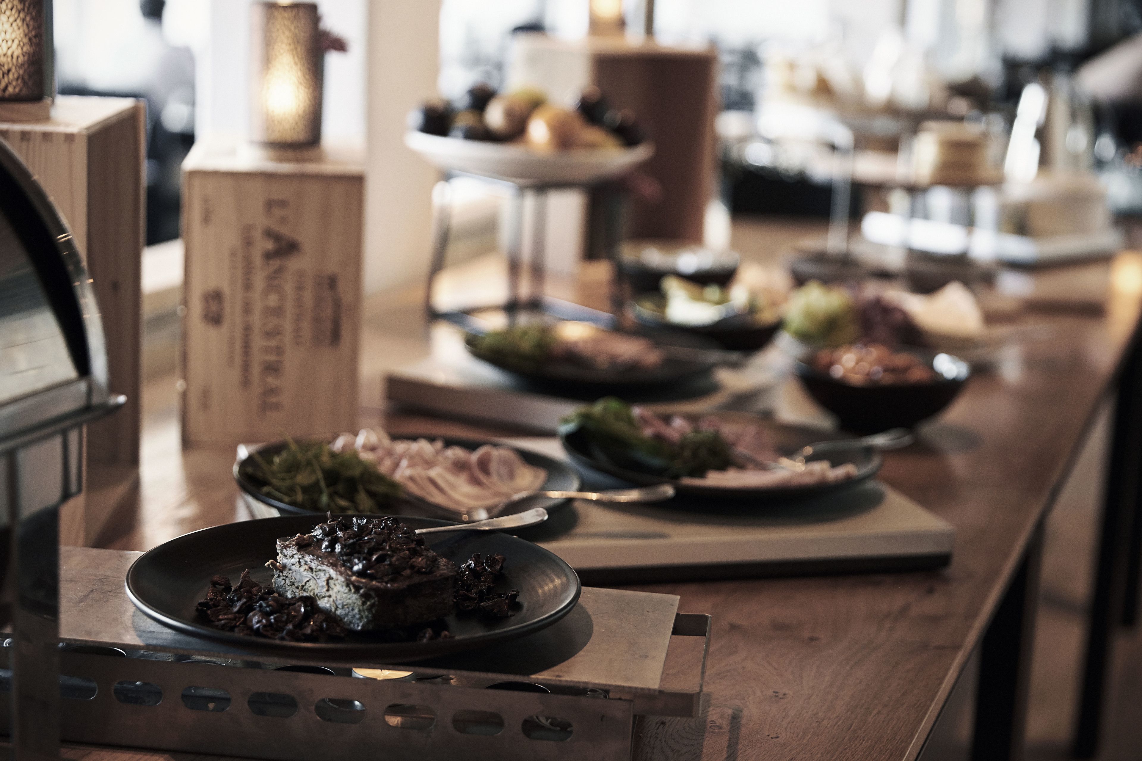 A buffet table with various dishes and a coffee machine.