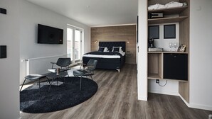 A modern bedroom with a bed, a desk, and a TV. - Hotel Skjern (Skjern)