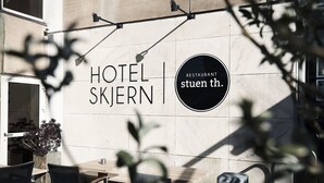 A modern hotel exterior with a sign for 'HOTEL SKJERN' and a restaurant named 'stuen th.' - Hotel Skjern (Skjern)