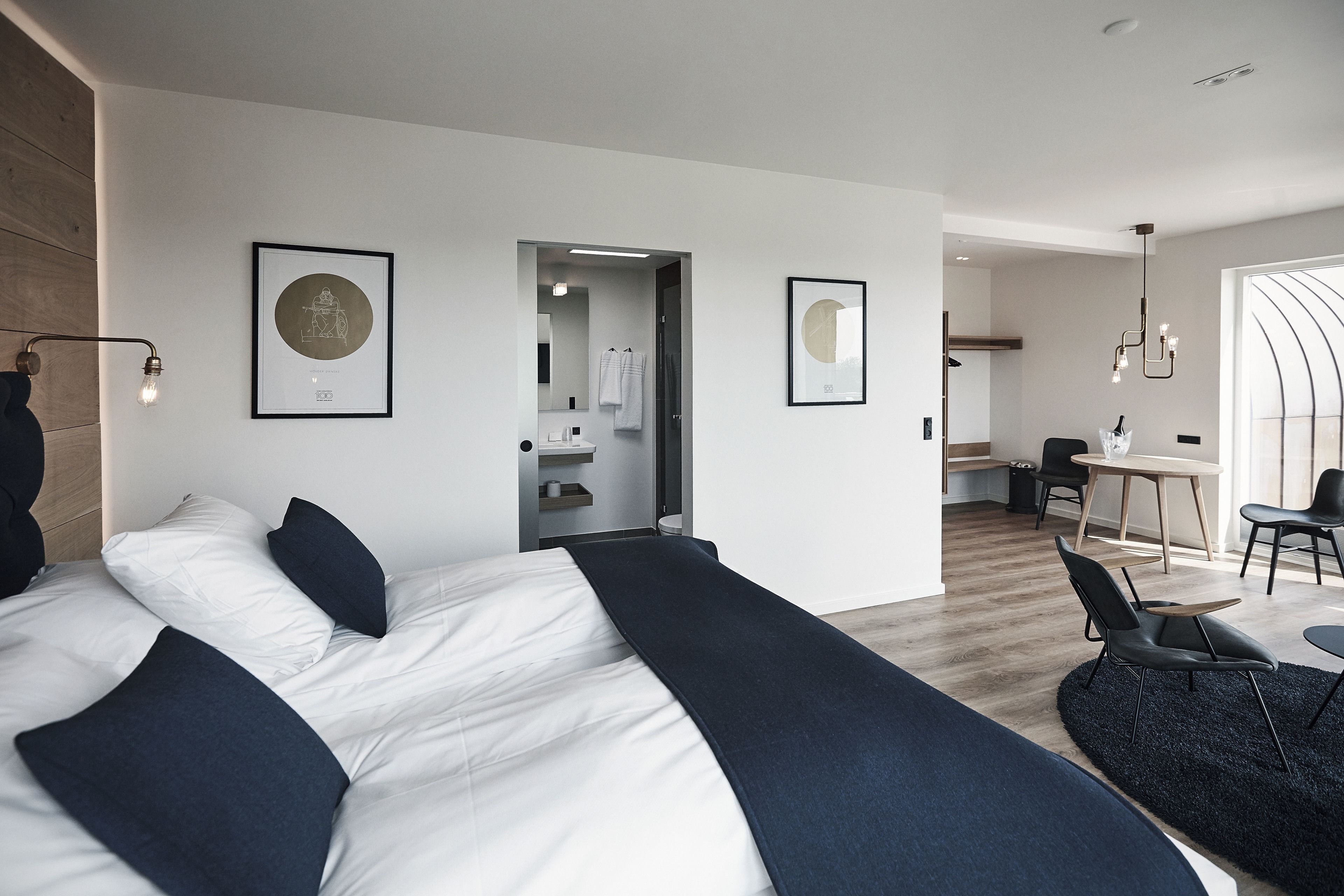 Une chambre d’hôtel moderne, dotée d’un grand lit, d’un bureau et d’un coin repas.