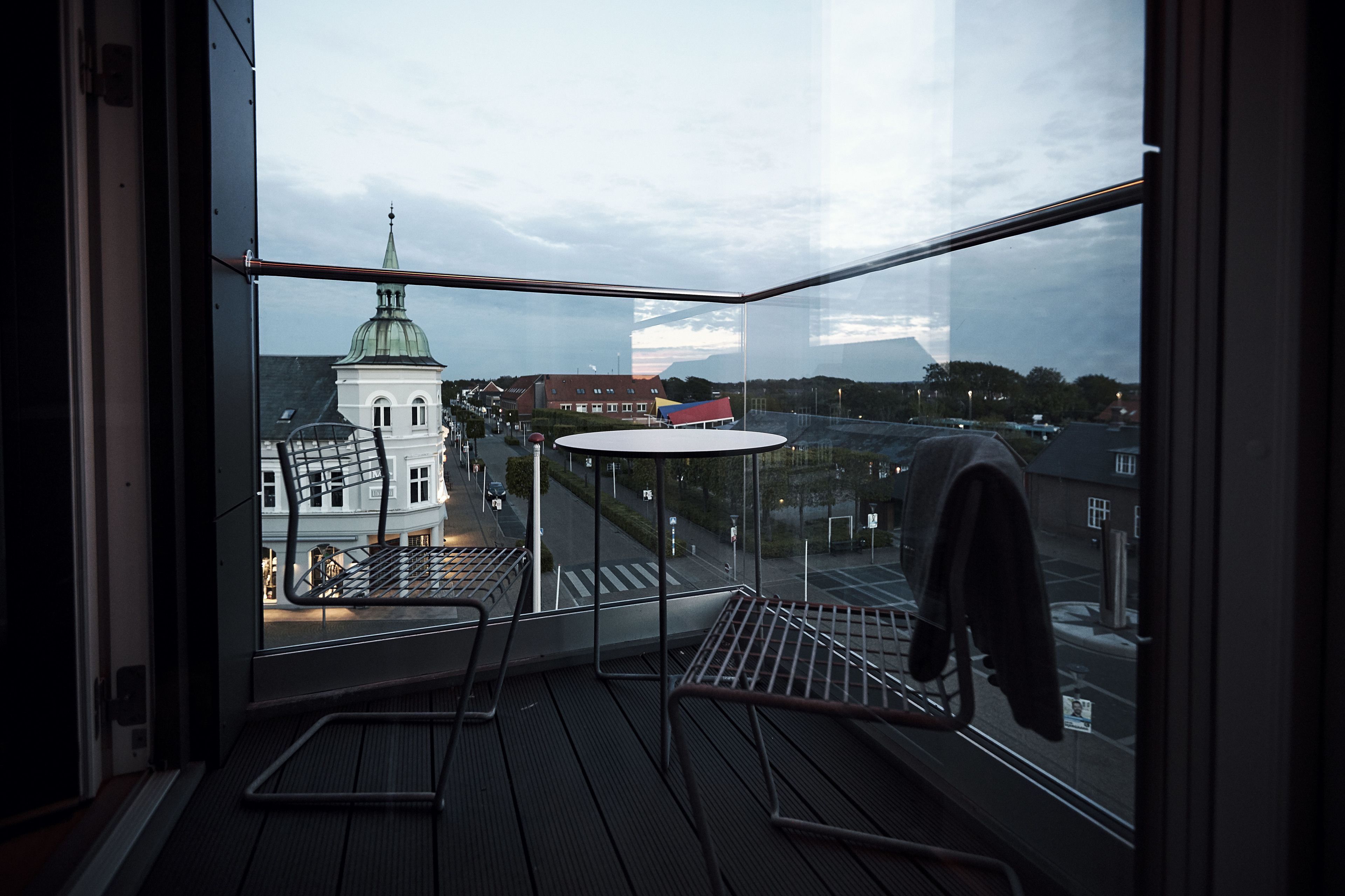A corner room with a view of a church and a street.