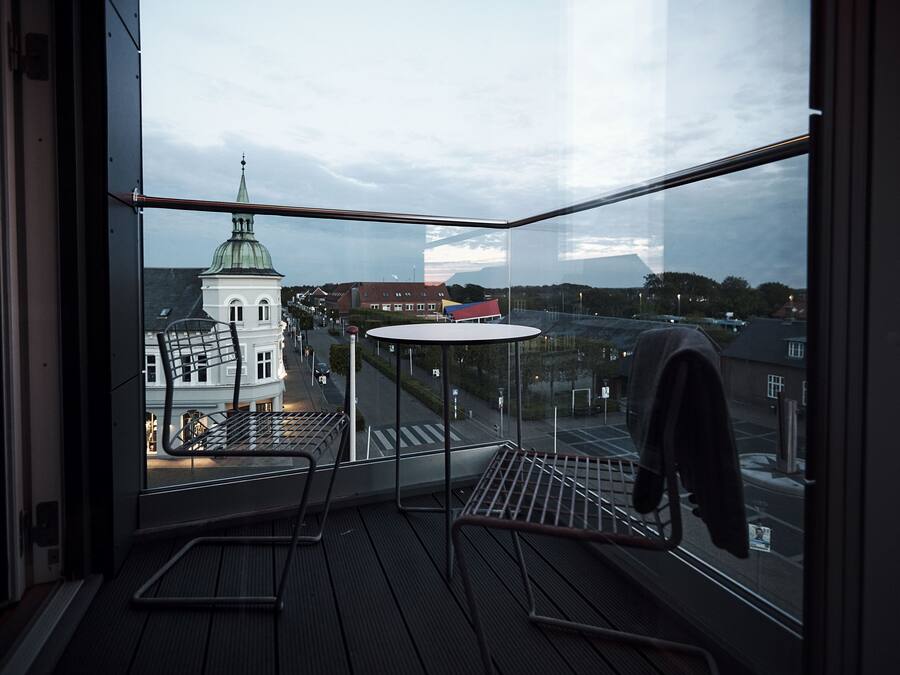 A corner room with a view of a church and a street.