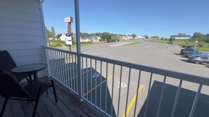 A motel with a signboard, a parking lot, and a view of the street. - Mon Joli Motel (Sainte-Flavie)