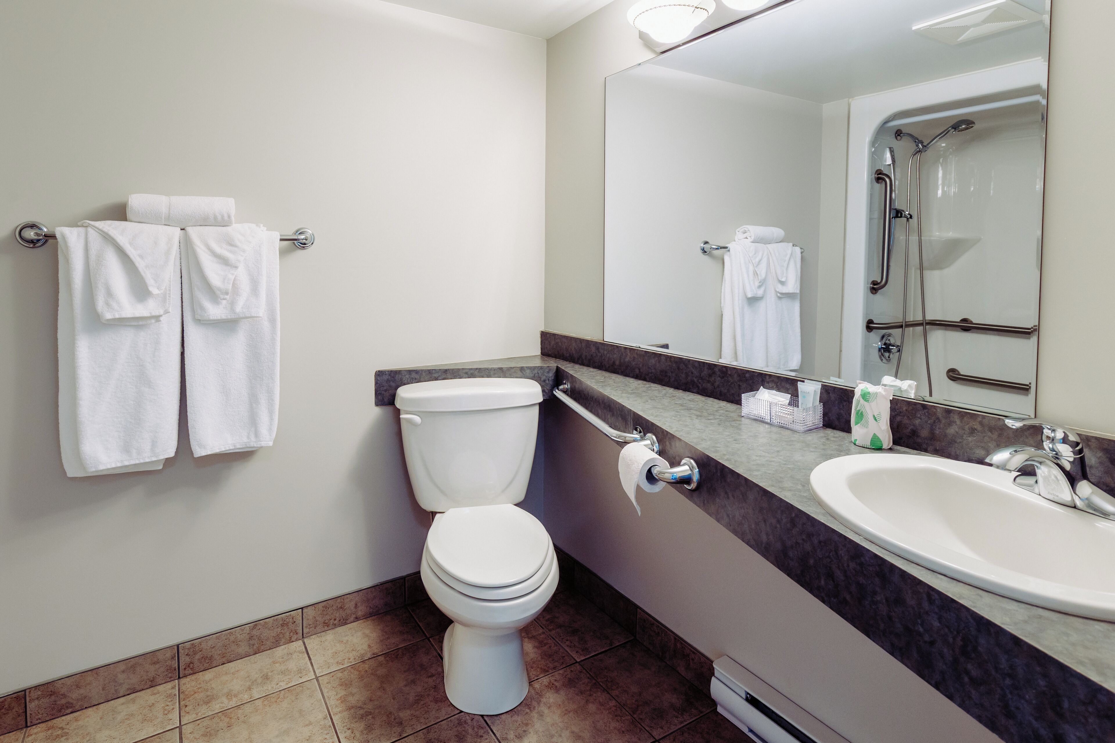 A modern bathroom with a toilet, sink, and shower.