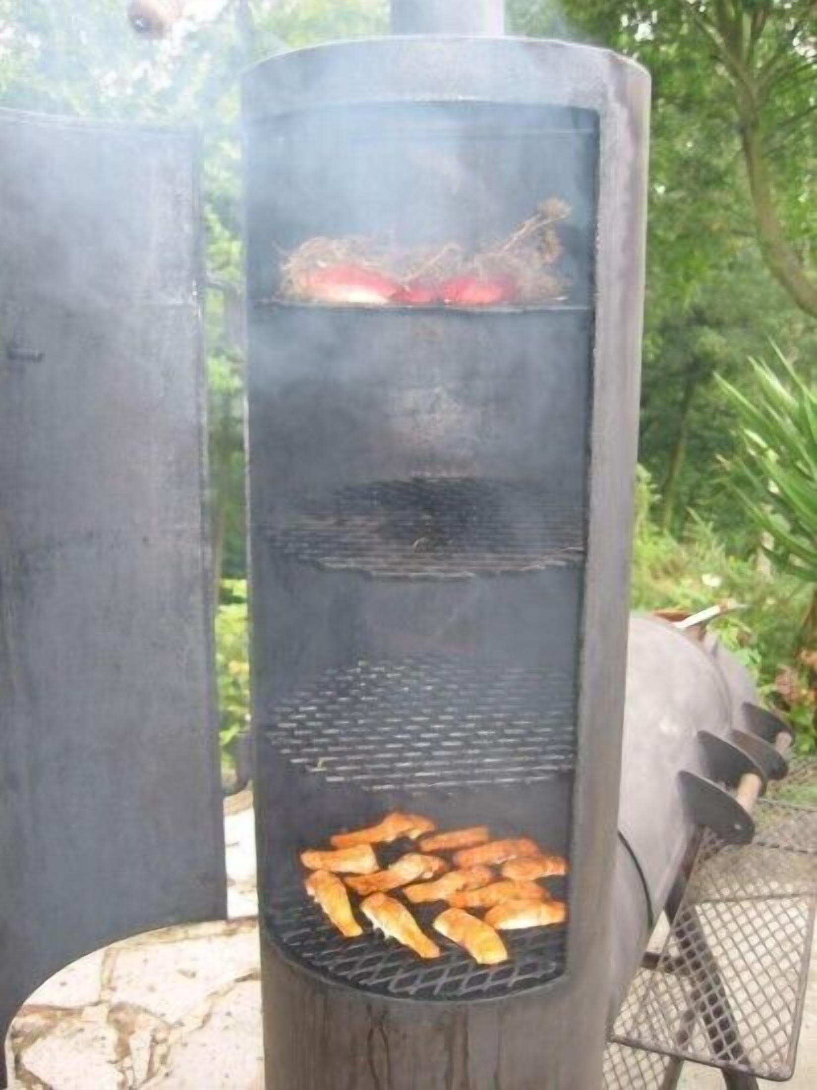 Een verticale grill met eten dat er op bereid wordt, omgeven door groen.