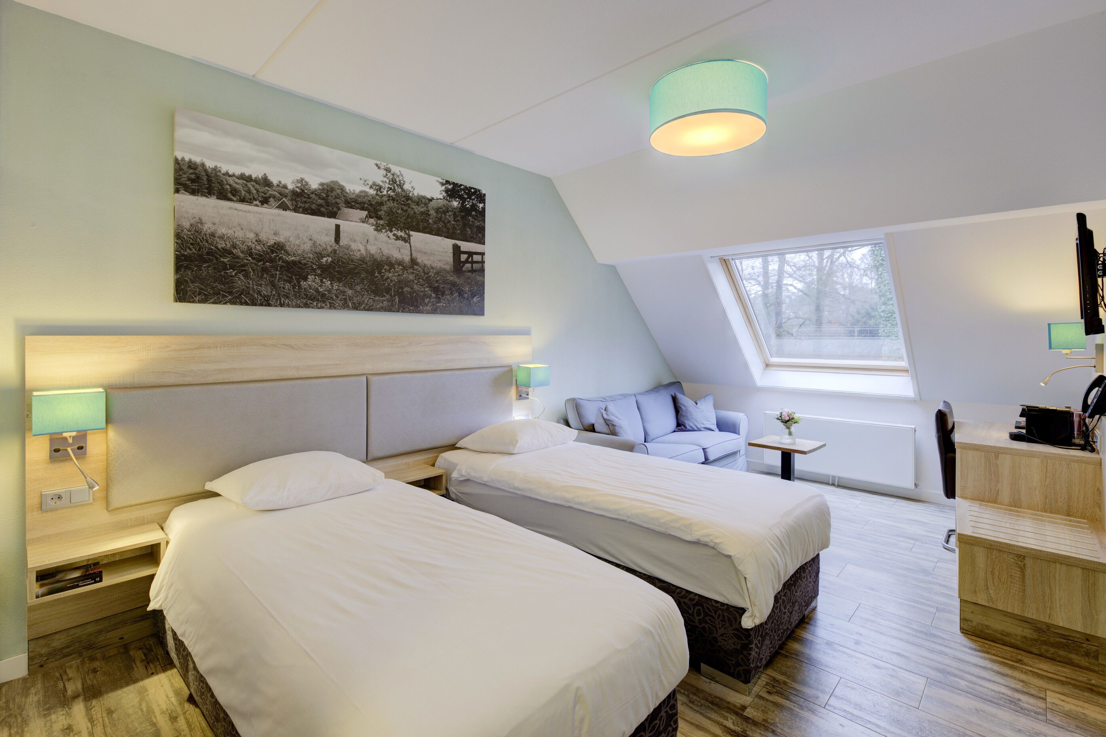 A modern hotel room with two beds, a desk, and a large window.