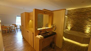 A modern bathroom with a stone wall, a sink, and a bathtub.
