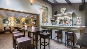 A restaurant with a bar area, high ceilings, and a large mirror. - Hotel Erve Hulsbeek (Oldenzaal)
