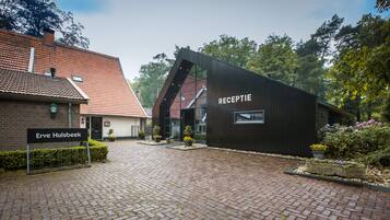 A building with a sign reading "Erve Hulsbeek" and another sign on the side that says "RECEPTIE".
