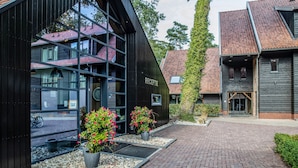 A building with a reception area, large windows, and a brick pathway. - Hotel Erve Hulsbeek (Oldenzaal)
