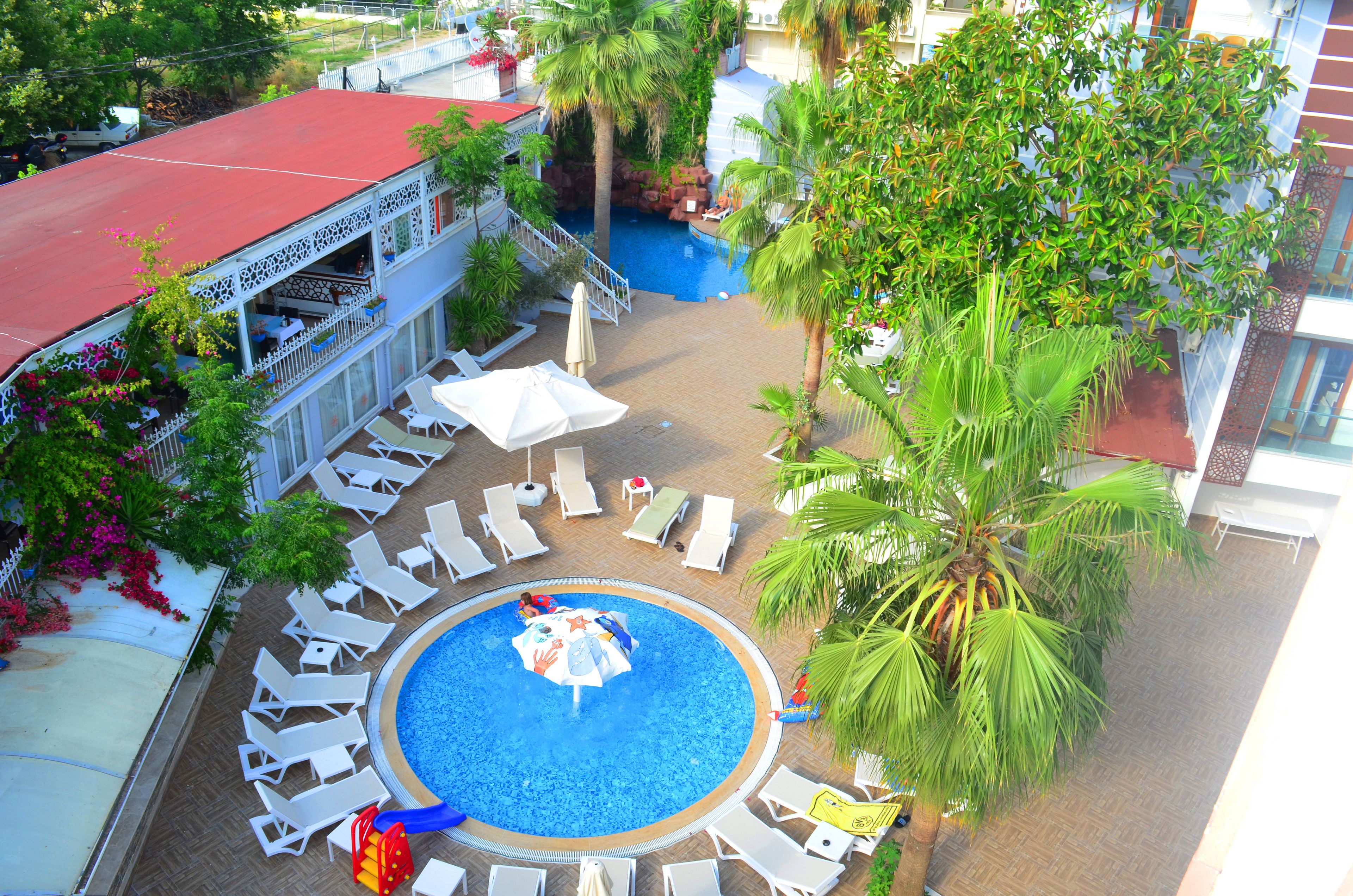 Een buitenzwembad, parasols bij het zwembad en ligstoelen
