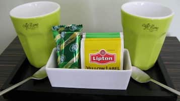 Una bandeja con dos tazas verdes, una caja de té Lipton Yellow Label y un paquete de bolsitas de té.